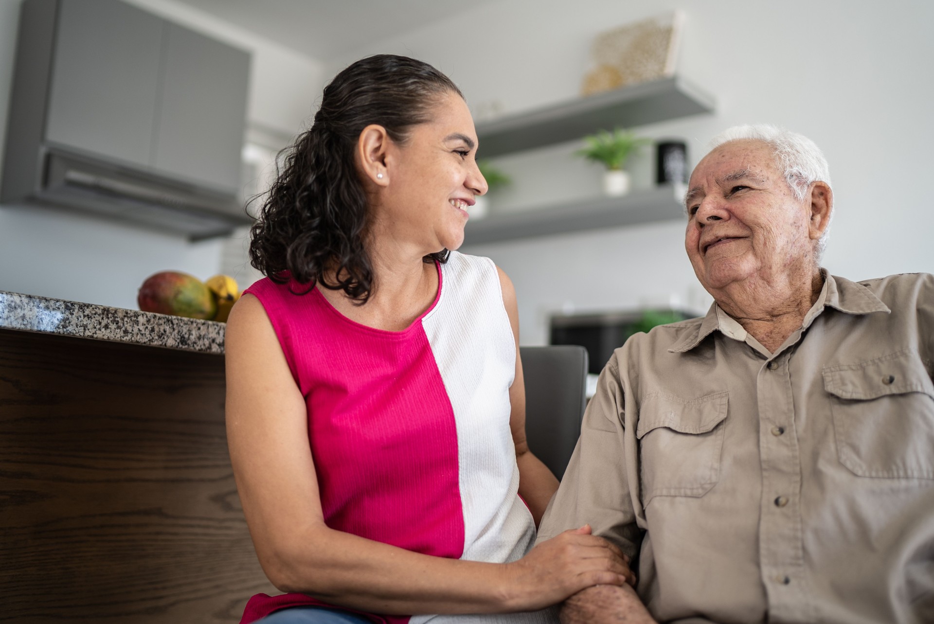 Senior man and his daughter (or home caregiver) talking at home